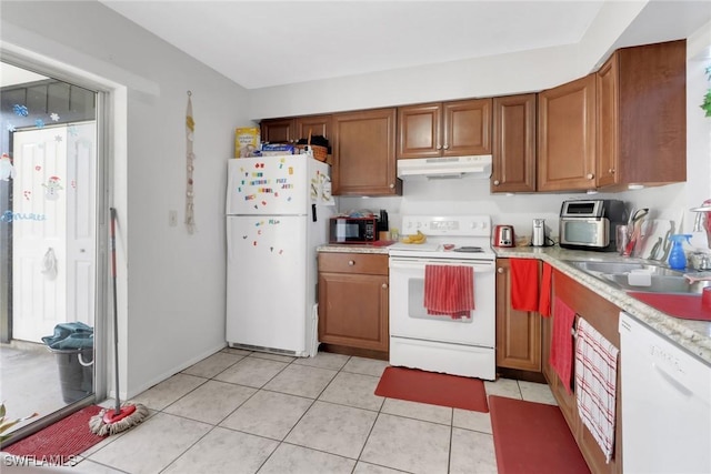 kitchen with white appliances, sink, and light tile patterned floors