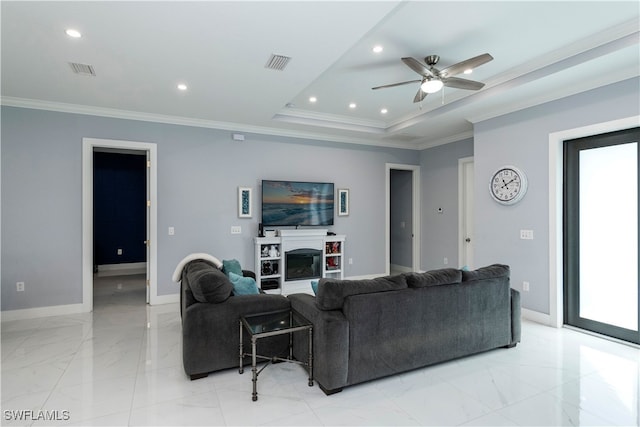 living room with crown molding, ceiling fan, and a tray ceiling