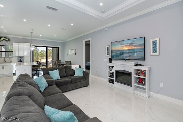 living room featuring sink and crown molding