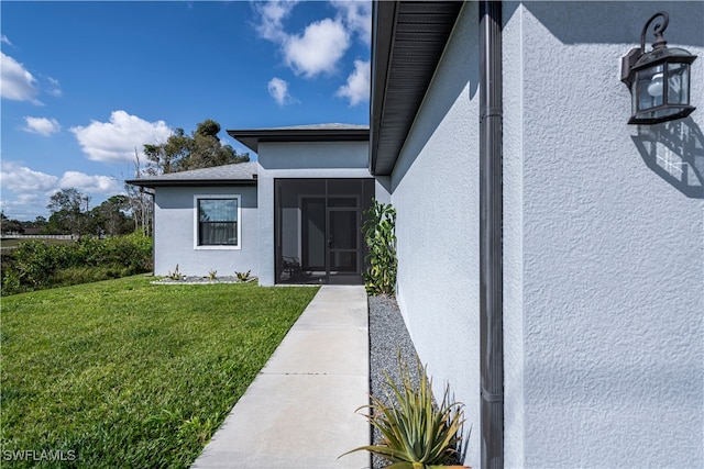 view of exterior entry with a lawn