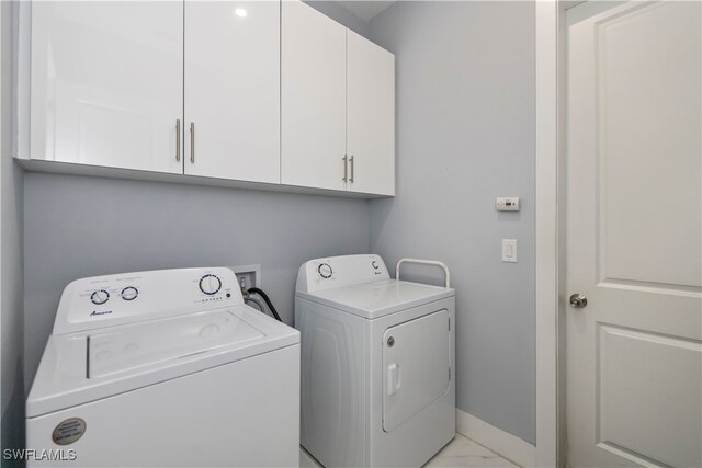 laundry area with washing machine and dryer and cabinets