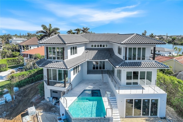 rear view of property featuring a water view and a balcony