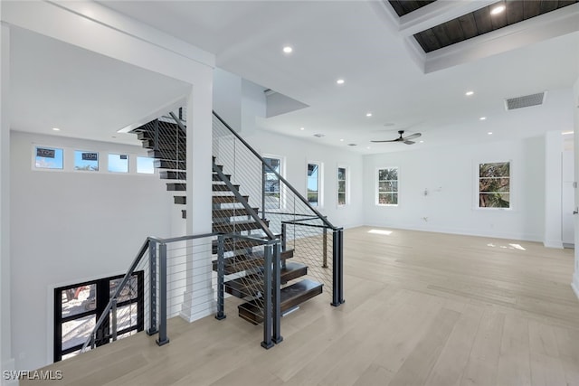 stairs featuring ceiling fan and hardwood / wood-style floors