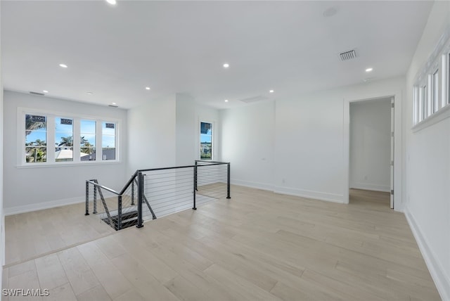 spare room featuring a healthy amount of sunlight and light hardwood / wood-style flooring