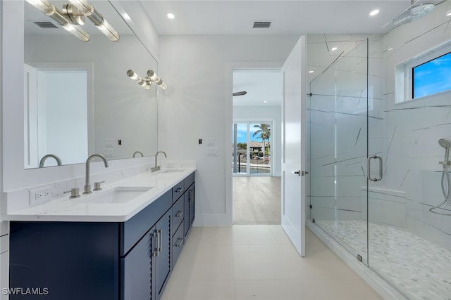 bathroom featuring tile patterned floors, vanity, and a shower with door