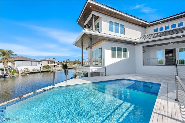 view of pool with an outdoor hot tub and a water view