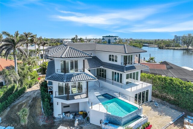 rear view of house featuring a water view, a balcony, and a patio area