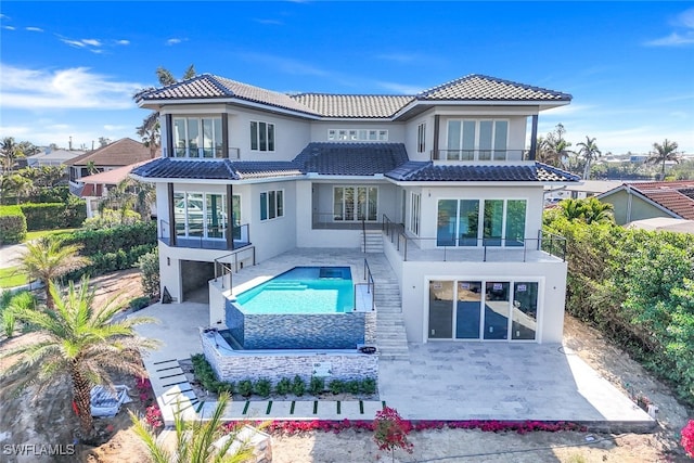 rear view of house featuring a balcony and a patio