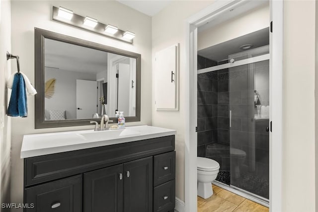 bathroom with vanity, hardwood / wood-style flooring, a shower with door, and toilet