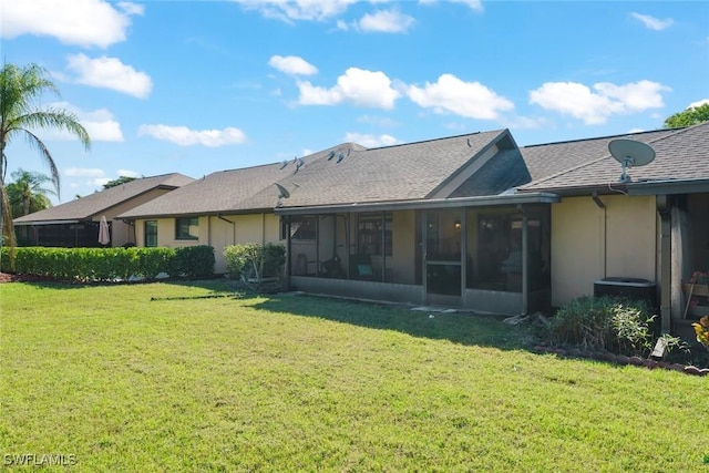 rear view of property with a sunroom and a lawn