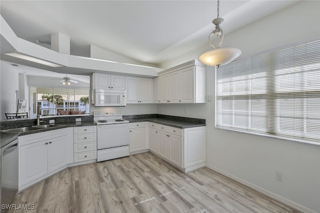 kitchen featuring sink, white appliances, hanging light fixtures, white cabinets, and vaulted ceiling