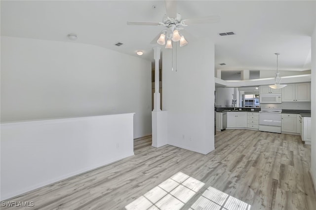 unfurnished living room with vaulted ceiling, sink, ceiling fan, and light wood-type flooring