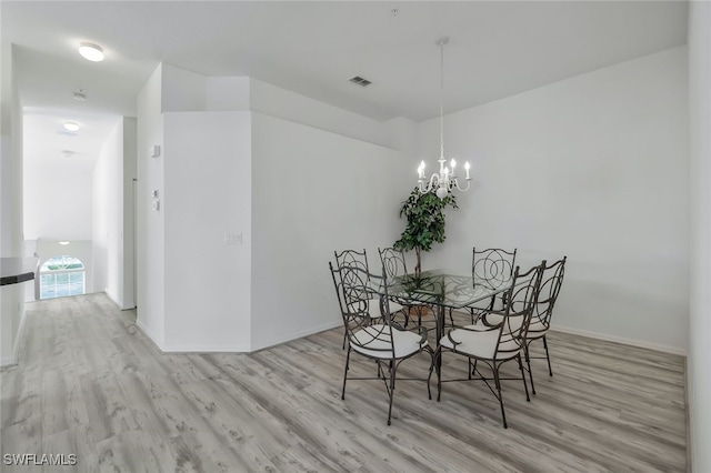 dining area with an inviting chandelier and light wood-type flooring