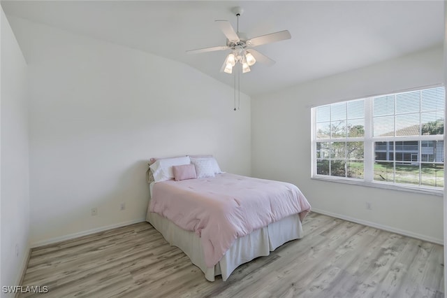 bedroom featuring ceiling fan, lofted ceiling, and light wood-type flooring