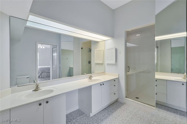 bathroom with vanity, toilet, and a shower with shower door