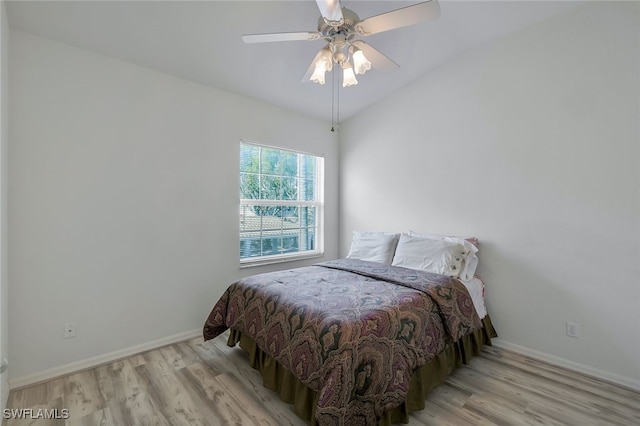 bedroom with vaulted ceiling, light hardwood / wood-style floors, and ceiling fan