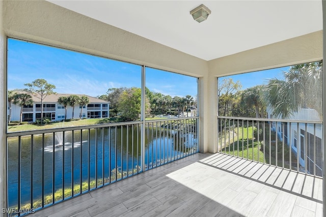 unfurnished sunroom featuring a water view