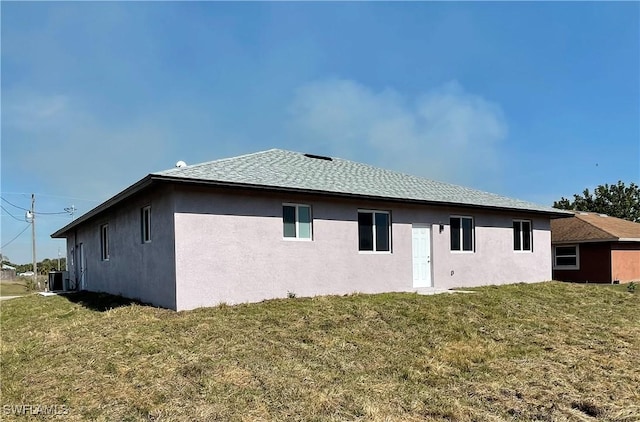 rear view of property with a yard and central AC