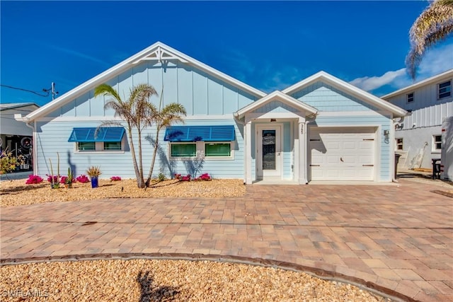 365 Donora Blvd, Fort Myers Beach, FL 33931 - single story home with decorative driveway, an attached garage, and board and batten siding