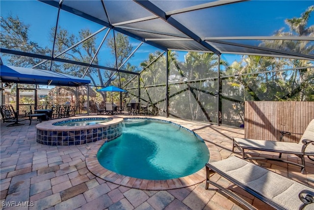 view of swimming pool with an in ground hot tub, a lanai, and a patio area