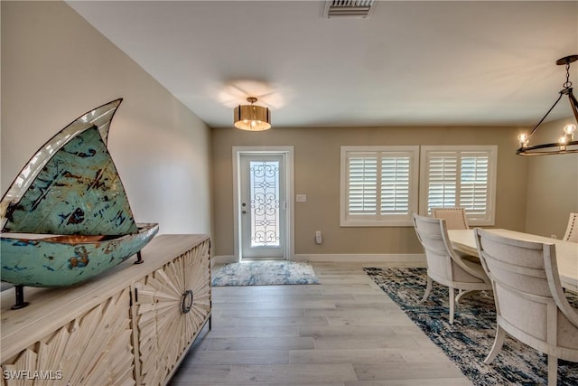 foyer entrance featuring a notable chandelier and light hardwood / wood-style flooring