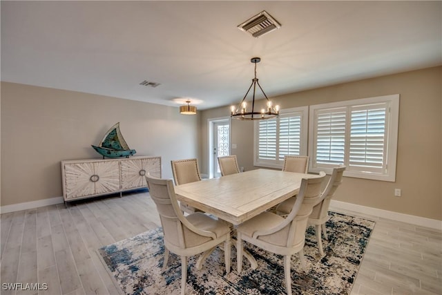 dining room featuring light hardwood / wood-style flooring and a notable chandelier