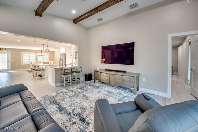 living room featuring beam ceiling and light wood-type flooring