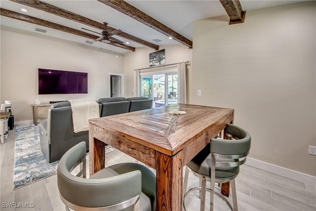 dining room with beam ceiling, light hardwood / wood-style floors, and ceiling fan