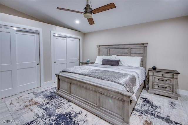 bedroom with multiple closets, ceiling fan, and light hardwood / wood-style flooring