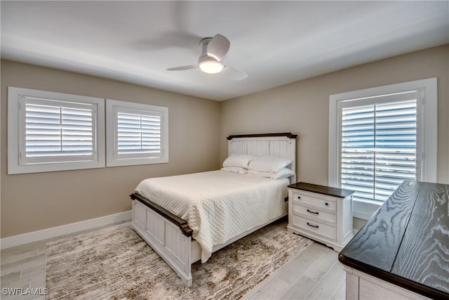 bedroom featuring multiple windows, light hardwood / wood-style flooring, and ceiling fan