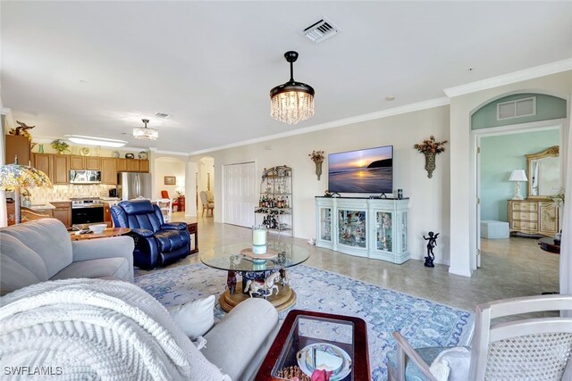 living room featuring a notable chandelier, crown molding, and light tile patterned flooring