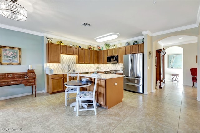 kitchen featuring a kitchen island, appliances with stainless steel finishes, sink, backsplash, and a kitchen breakfast bar