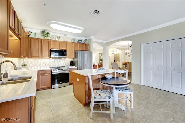 kitchen featuring a kitchen bar, sink, a kitchen island, stainless steel appliances, and backsplash