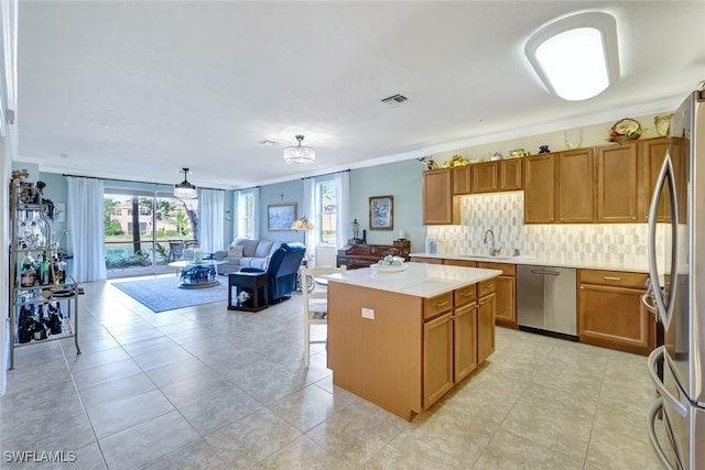 kitchen featuring sink, crown molding, stainless steel appliances, and a kitchen island