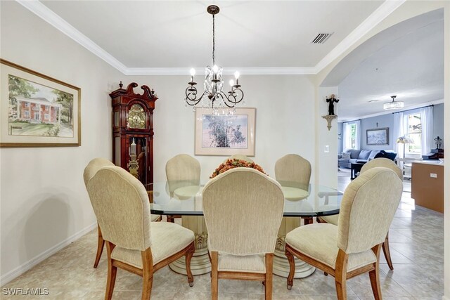 dining area with an inviting chandelier, light tile patterned floors, and crown molding