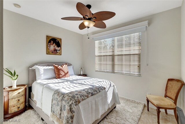 tiled bedroom featuring ceiling fan