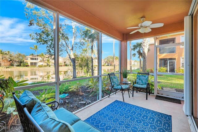 sunroom featuring a water view and ceiling fan