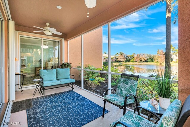 sunroom with a water view and ceiling fan