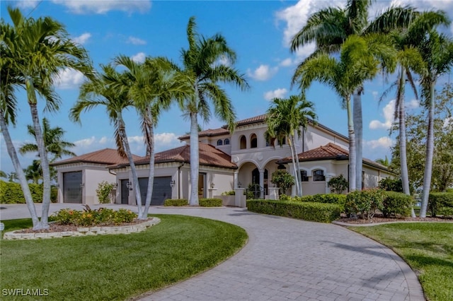 mediterranean / spanish-style home featuring a garage and a front yard