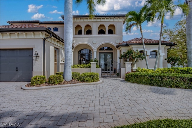 mediterranean / spanish-style home featuring a garage and french doors