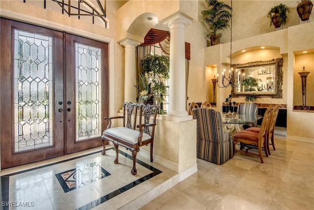 entryway featuring decorative columns, french doors, and a high ceiling