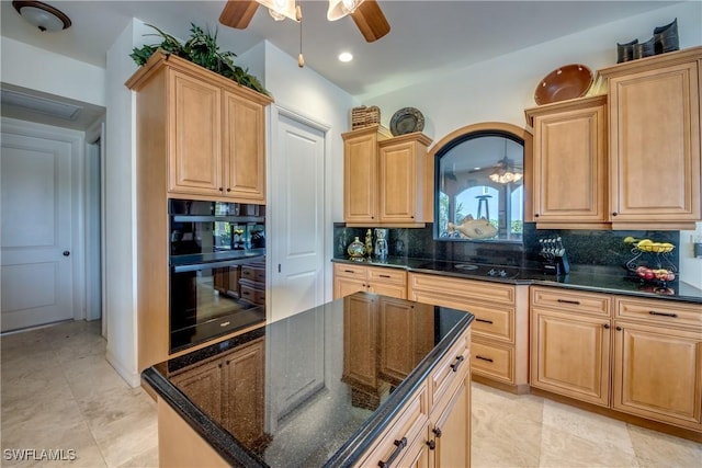 kitchen featuring dark stone counters, a center island, decorative backsplash, and light brown cabinets