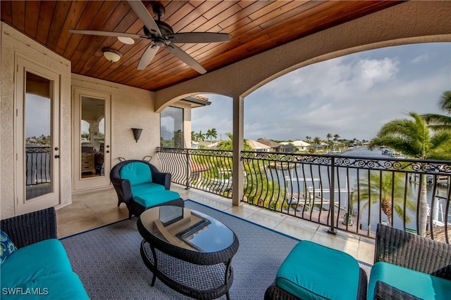 balcony with ceiling fan and a water view