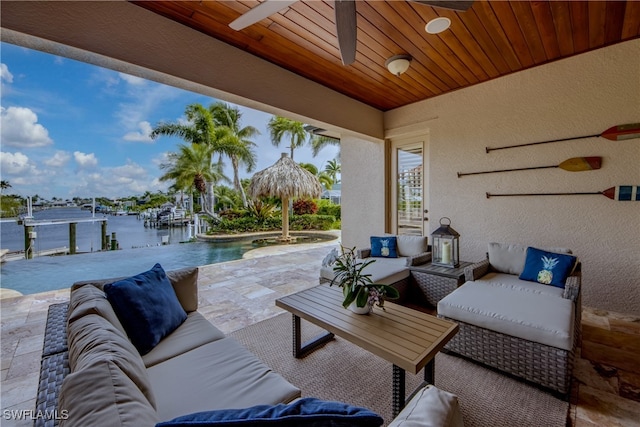 view of patio / terrace featuring a water view, ceiling fan, and an outdoor living space