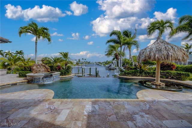 view of swimming pool with a water view, pool water feature, an in ground hot tub, and a patio