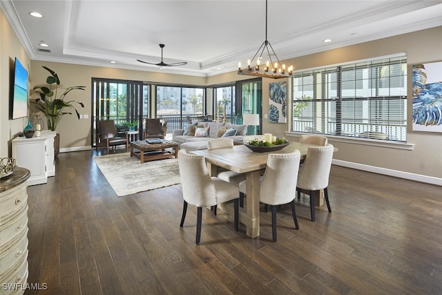 dining area with ornamental molding, dark hardwood / wood-style flooring, a raised ceiling, and a wealth of natural light