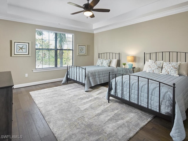 bedroom with a raised ceiling, crown molding, ceiling fan, and dark hardwood / wood-style flooring