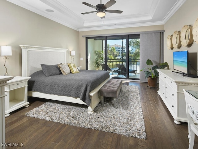 bedroom with dark wood-type flooring, ornamental molding, a tray ceiling, and access to exterior