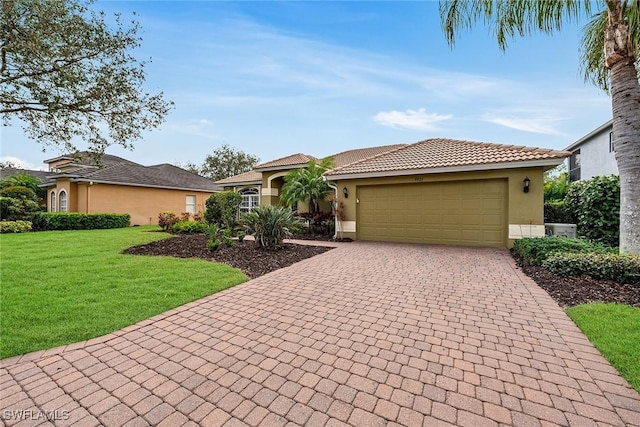 mediterranean / spanish-style house featuring a garage and a front lawn