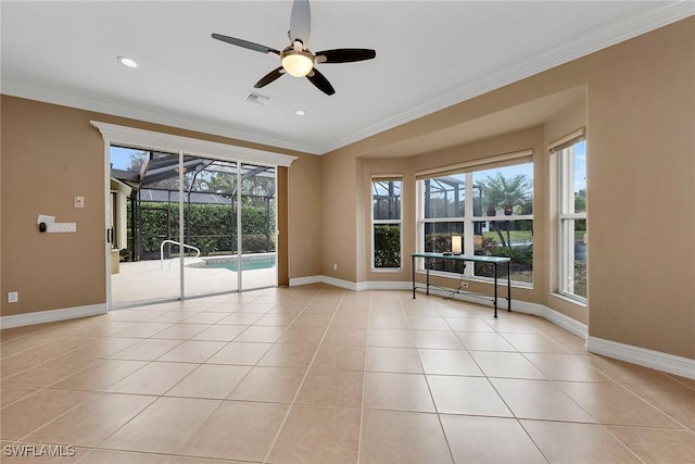 spare room with light tile patterned flooring, ornamental molding, and ceiling fan